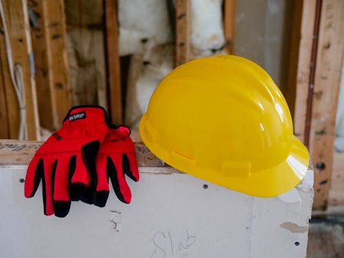 黄色いヘルメットと赤い保護手袋のクローズアップ写真