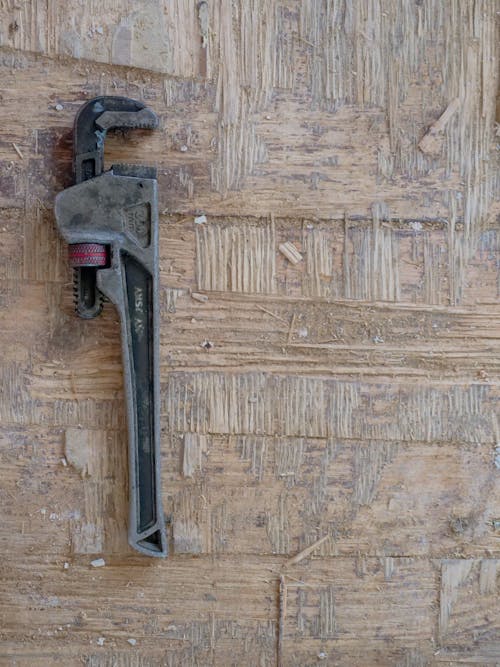 Close Up Photo of Plumbers Wrench on Wooden Surface