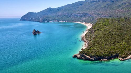 Free Stunning aerial view of the turquoise waters and lush coastline of Setúbal, Portugal on a bright summer day. Stock Photo