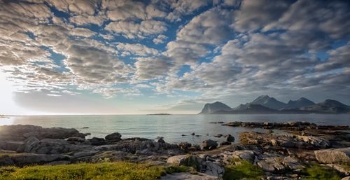 Free Breathtaking view of Nordland's rocky coastline and mountains under a dramatic sky at sunrise. Stock Photo
