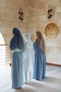 Woman in White Hijab Standing Near White Tiled Wall