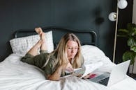Woman Looking at the Papers While Lying on Bed