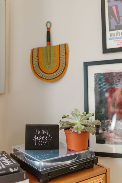Free Inviting home decor featuring a vinyl player, woven fan, and potted succulent for a retro-modern vibe. Stock Photo