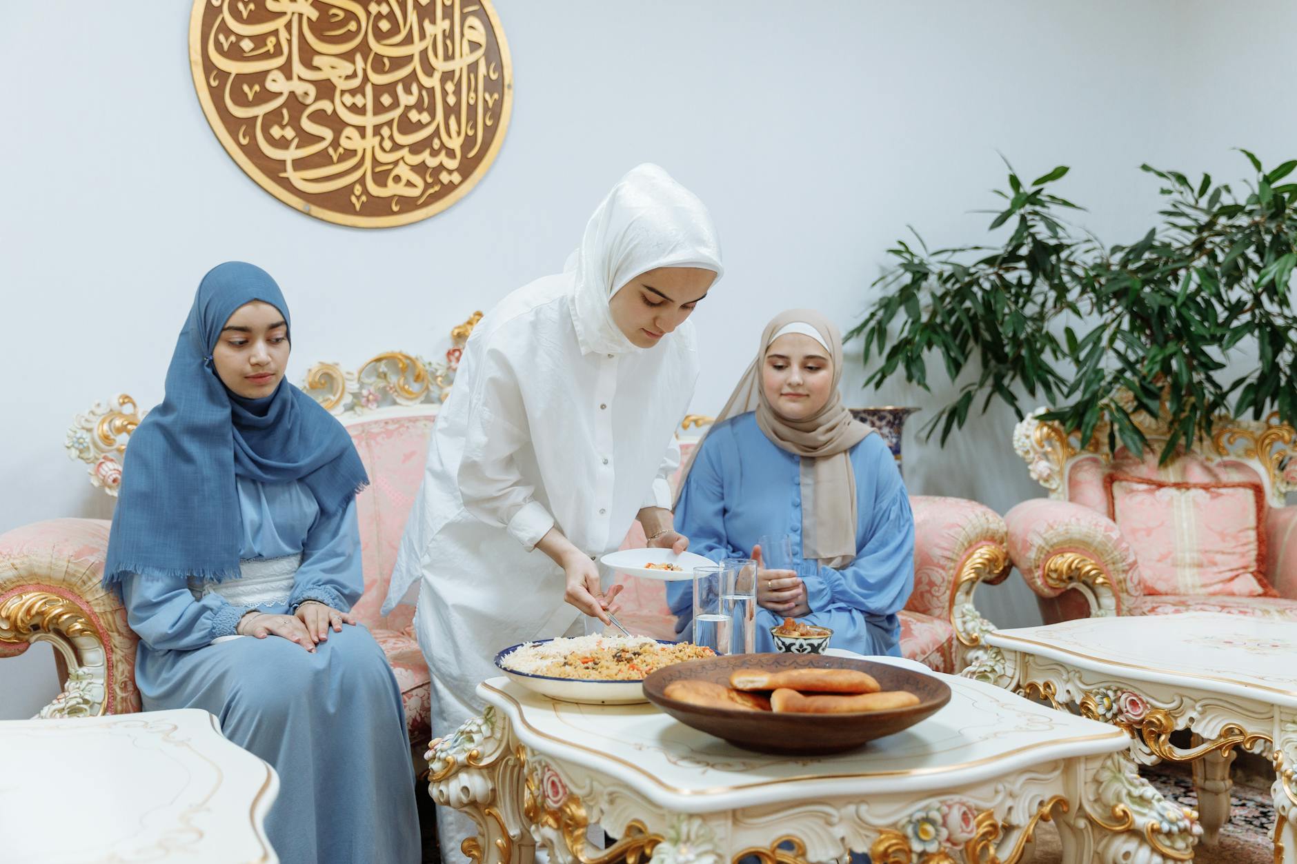 Muslim women preparing and enjoying iftar meal during Ramadan indoors.