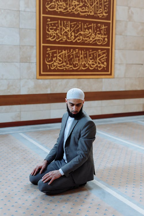 Man in Gray Coat Kneeling on Floor