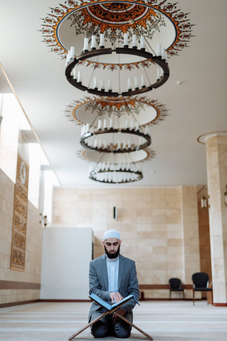 A Bearded Man In A Suit Reading A Book