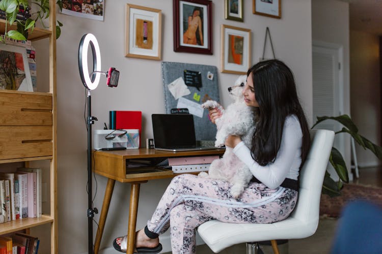 A Woman Recording With Her Pet Dog At Home