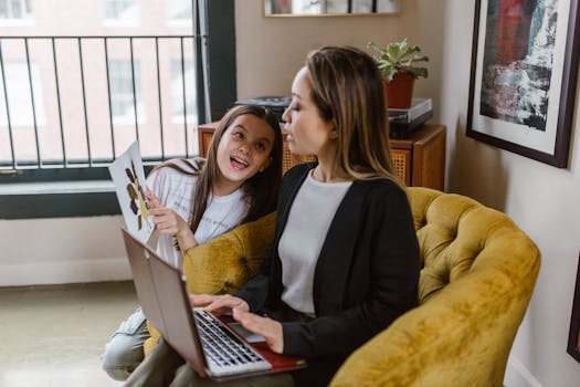 A mother and daughter share a joyful moment during remote work at home, embracing family time.