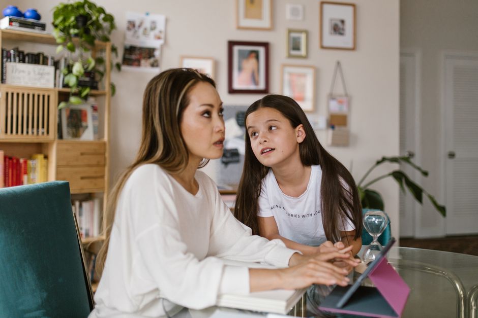 A mother and daughter spending quality time using a digital tablet at home, fostering connection.