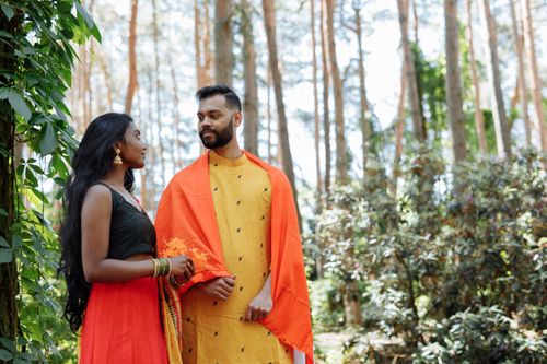 Free Indian couple in vibrant traditional clothing enjoying an outdoor setting, symbolizing cultural heritage. Stock Photo