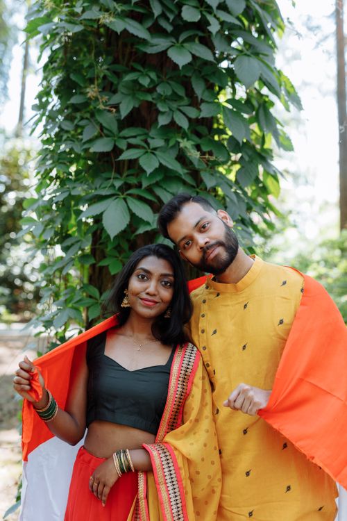 Free Smiling Indian couple outdoors in traditional dress, wrapped in the Indian flag. Stock Photo