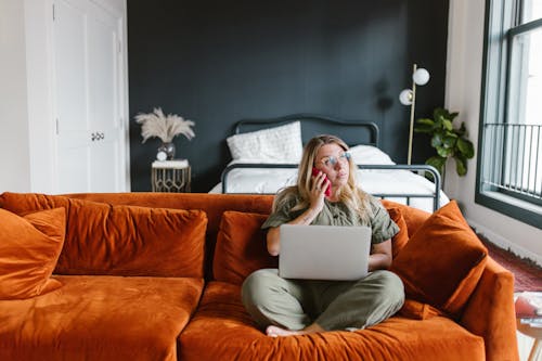 Woman Sitting on Sofa While on Phone Call