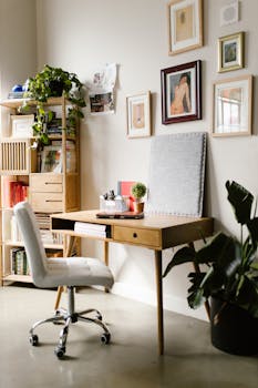 A cozy and tidy home office featuring a wooden desk, lush houseplants, and stylish wall art.