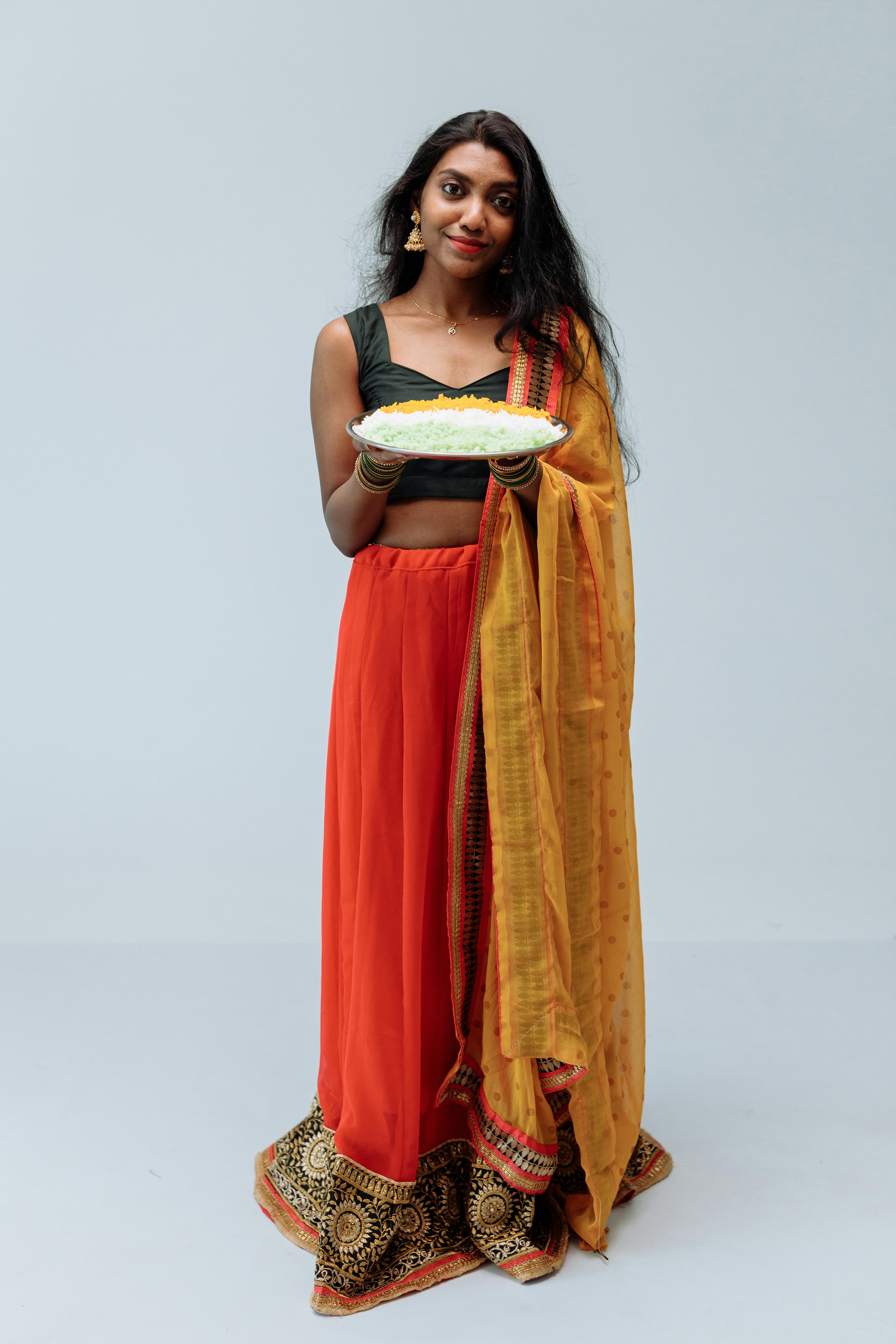 南亚妇女在充满活力纱丽举行传统米饭盘，工作室肖像