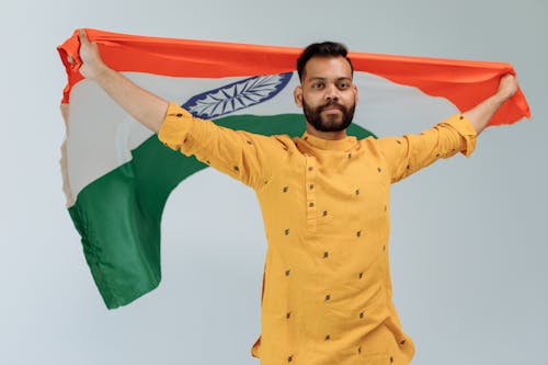 Bearded Man Carrying Indian Flag while Seriously Looking at the Camera