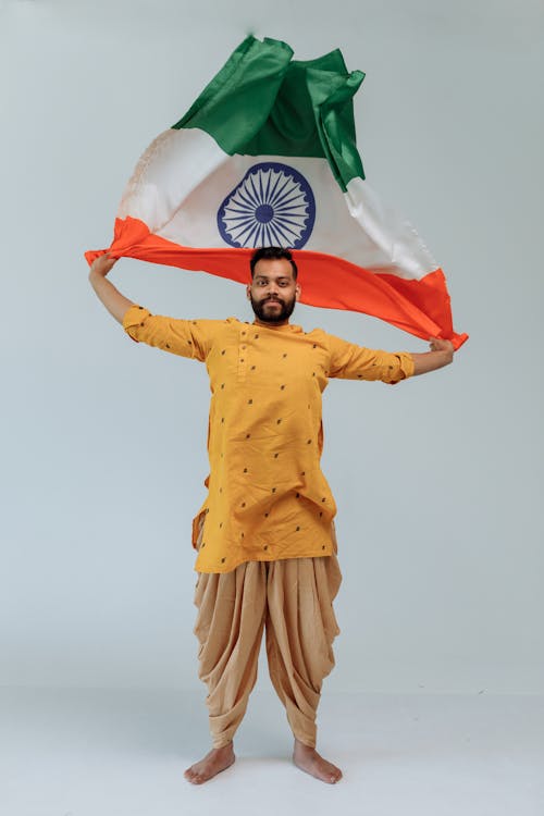 A Bearded Man in Traditional Outfit Holding an Indian Flag