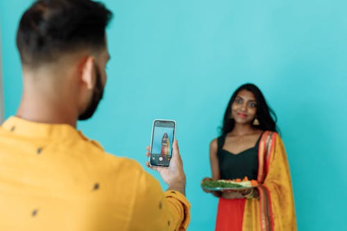 A Man Taking a Picture of a Woman with His Smartphone