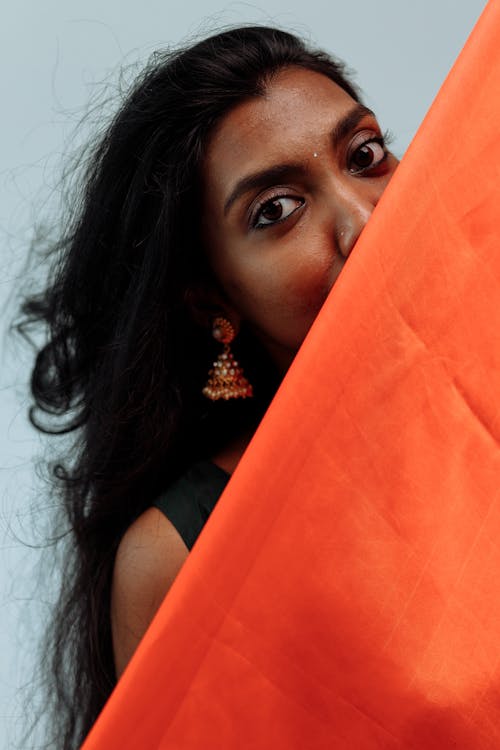 A Woman Behind An Orange Textile