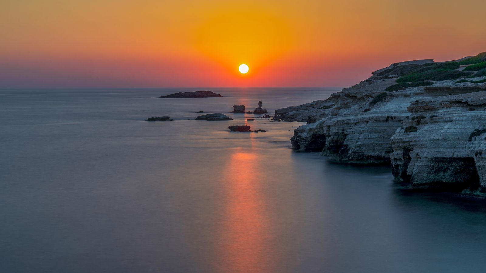 Rocky coastline under a vivid sunset, photo by chris clark on Pexels