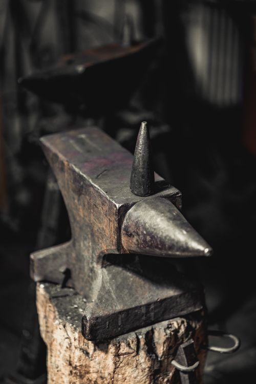Free A detailed view of a heavy iron anvil used in metalwork, showcasing its rugged texture. Stock Photo