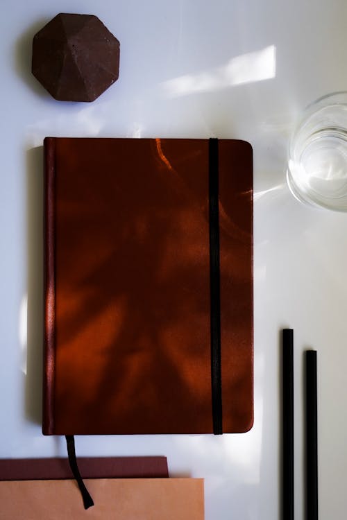 Foto profissional grátis de caderno, capa, copo de água