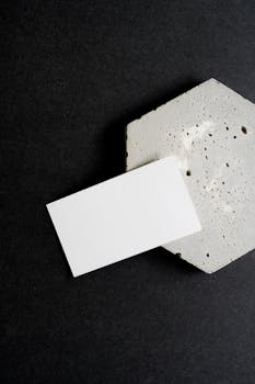 Minimalist business card resting on a textured concrete surface, ideal for branding mockups.