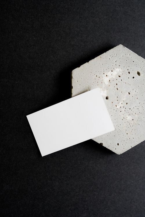 Free Minimalist business card resting on a textured concrete surface, ideal for branding mockups. Stock Photo