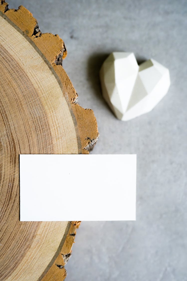 Blank Rectangle Paper On A Wooden Surface Near A Heart Shaped Toy On The Ground