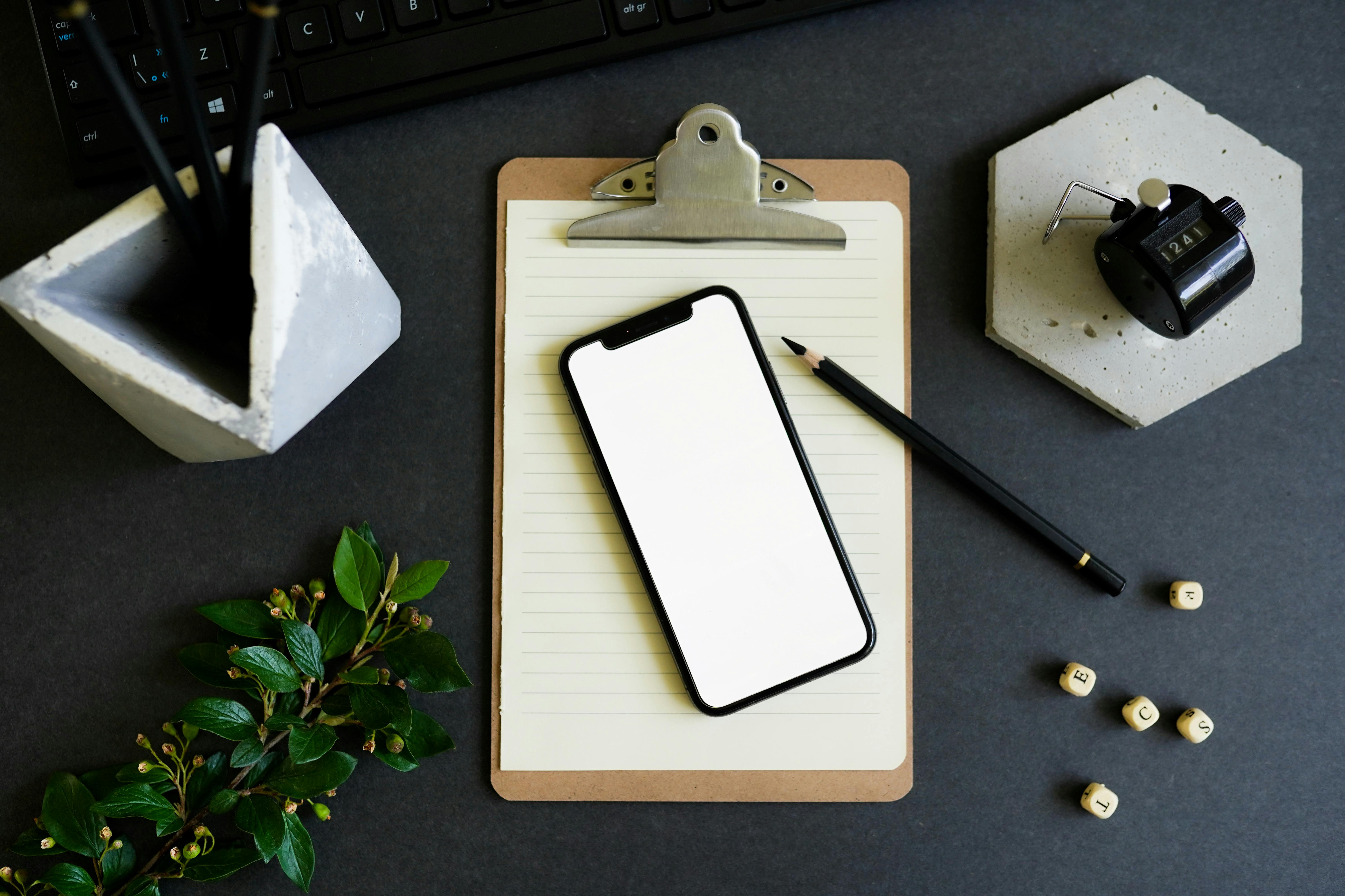 Cellphone and Pencil on Clipboard · Free Stock Photo
