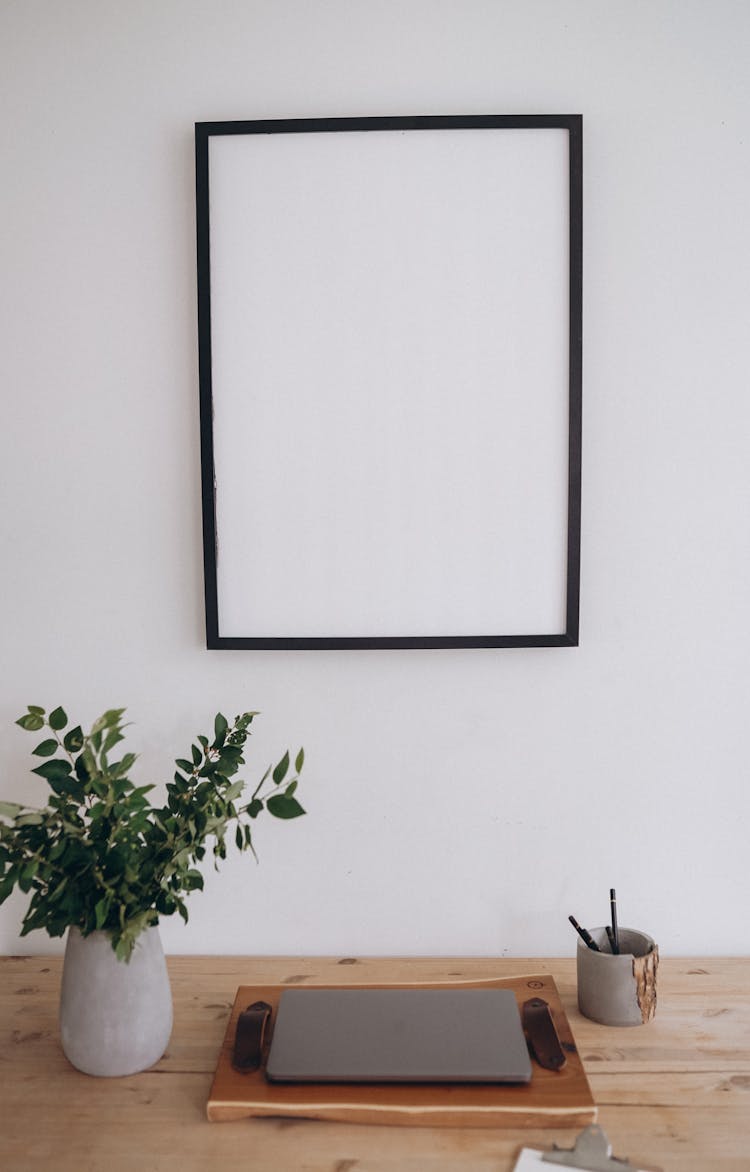 Empty Picture Frame Over Laptop On Desk
