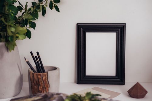 Free Elegant black frame on desk with pencils and greenery, perfect for a minimalist setup. Stock Photo