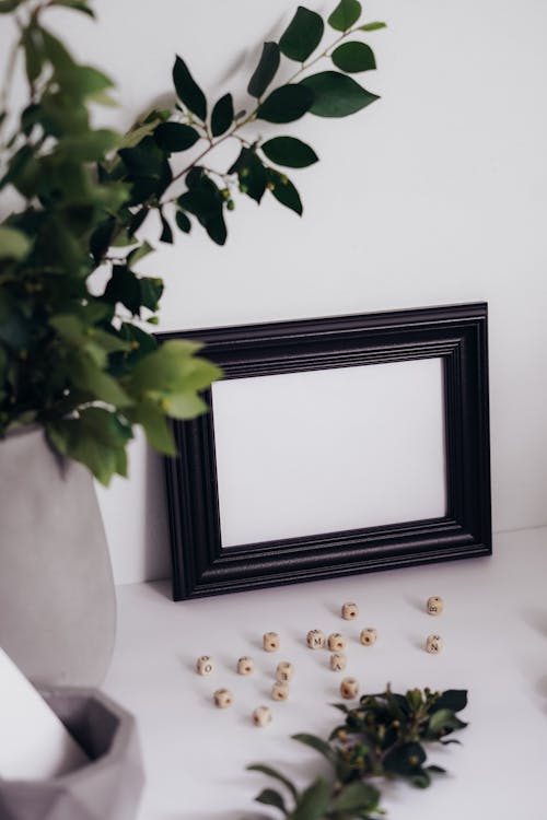 A Blank Picture Frame and Dice on the Table 