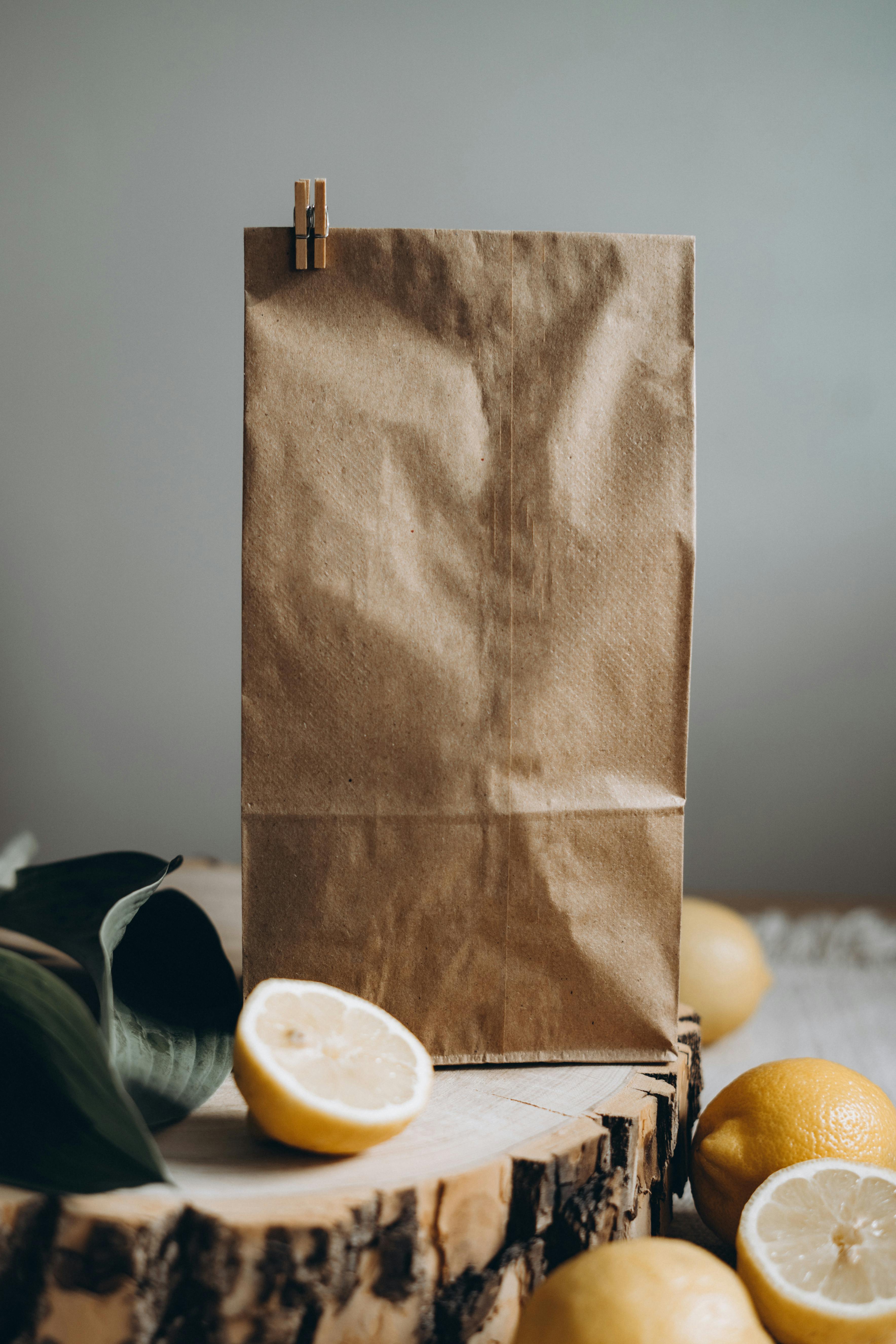 Fresh citrus in mesh bag on beige background. Lemons and limes in