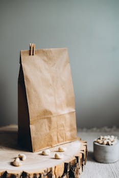 Stylish brown paper bag with cashews on a wooden board, perfect for eco-conscious themes.