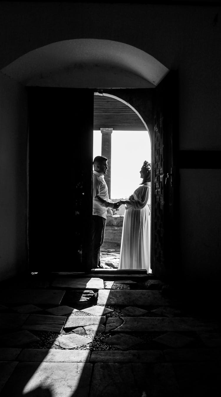 Black And White Photo Of Newlyweds Standing In Door Frame