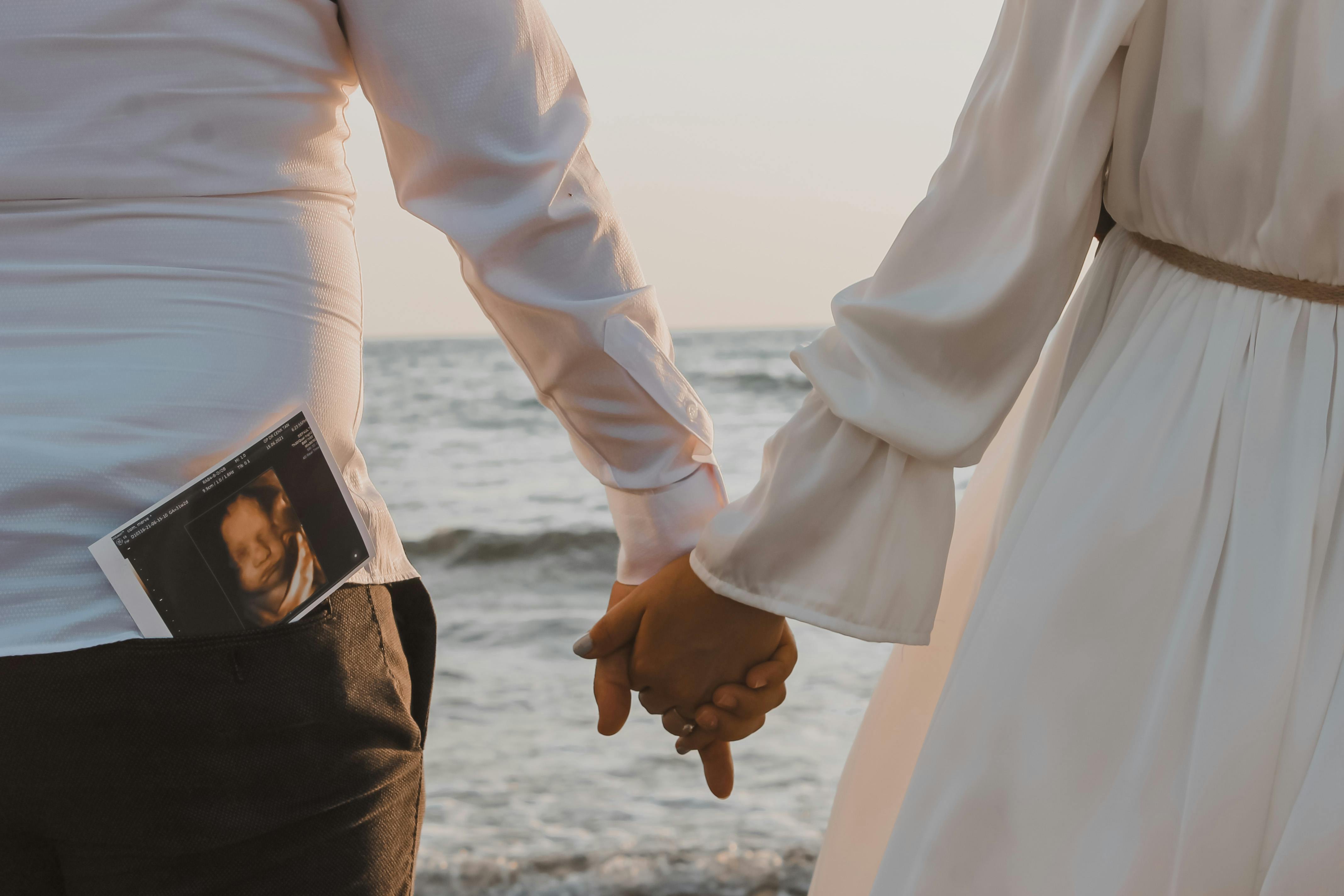 A Couple Holding Hands by the Beach · Free Stock Photo