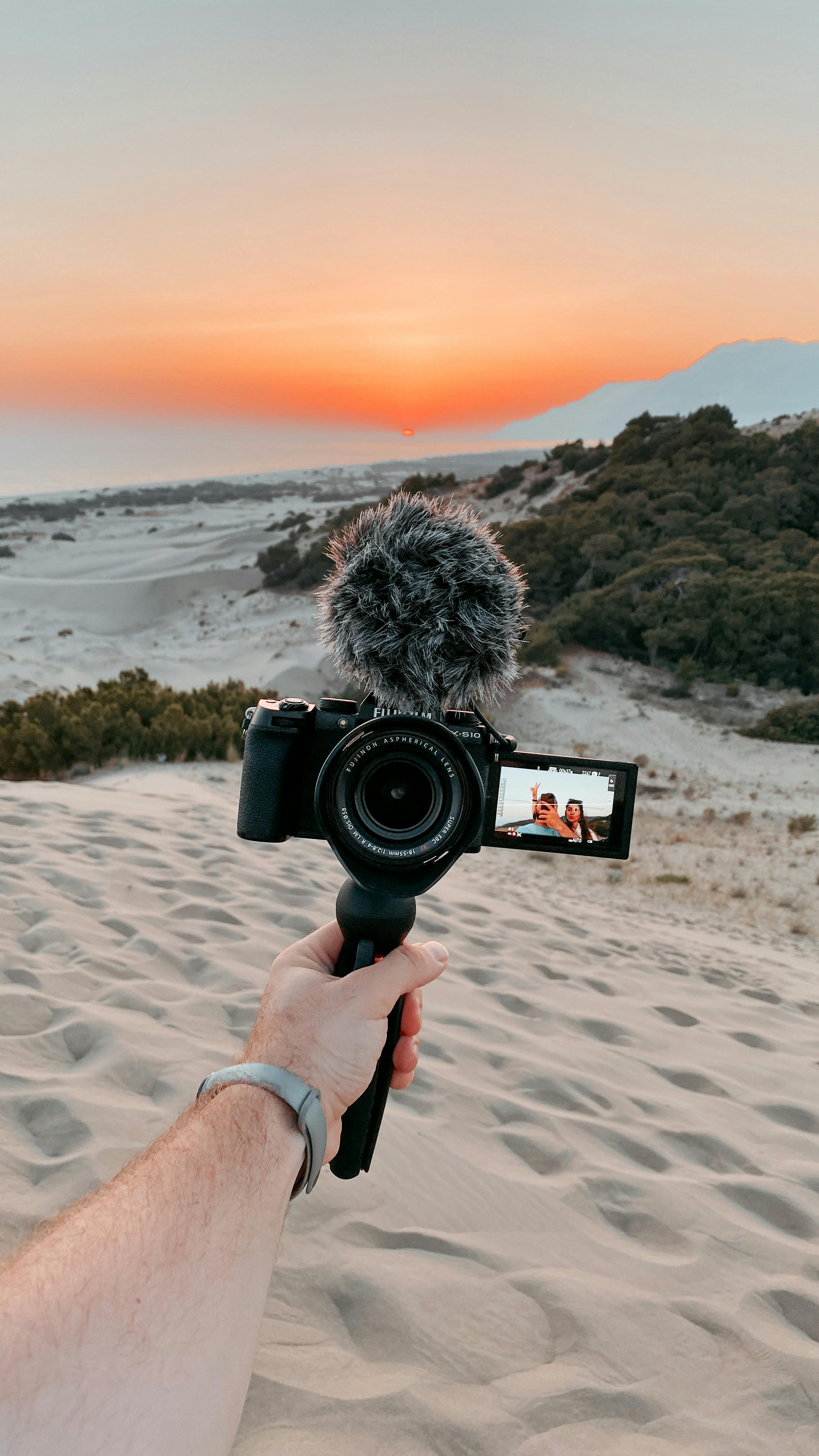 a person holding a camera with microphone