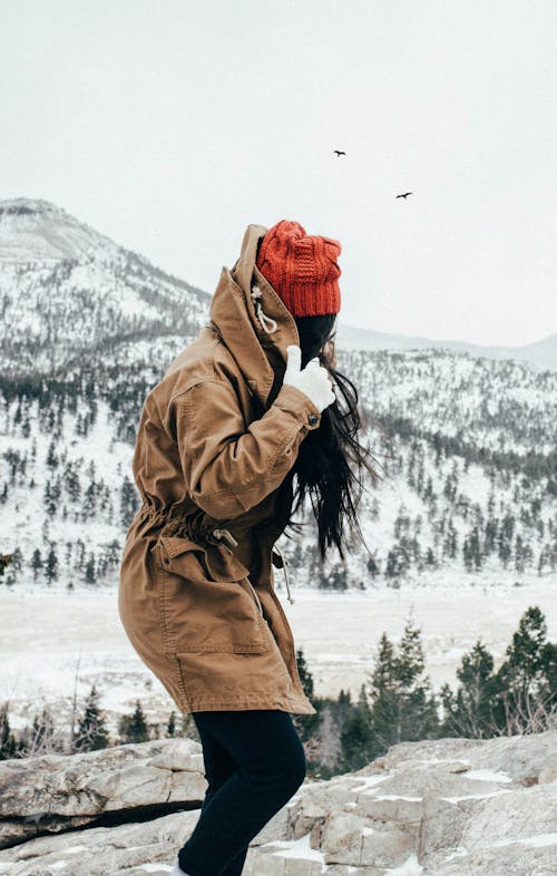 Woman in Brown Jacket Wearing Red Knitted Beanie 