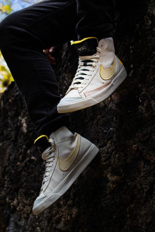 Free Trendy white sneakers on a rock surface showcasing urban fashion vibes. Stock Photo
