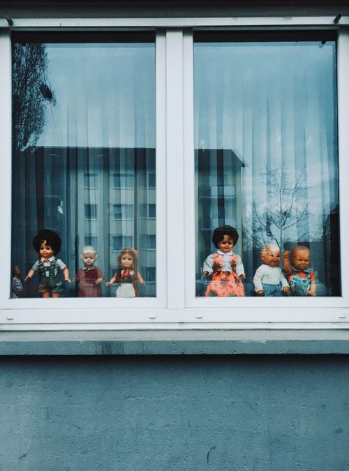 Free Group of vintage dolls displayed in a window, capturing nostalgic and retro vibes in Frankfurt, Germany. Stock Photo
