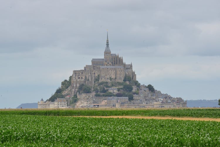 Mont Saint-michel Under White Clouds And Blue Sky