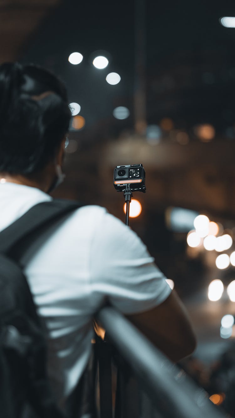 A Person In White Shirt Holding Go Pro Camera