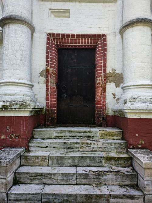 Free Weathered stone steps leading to an old wooden door framed by brick. Stock Photo