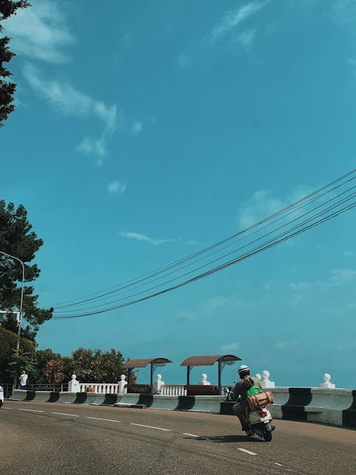 Person Riding a Scooter on the Road