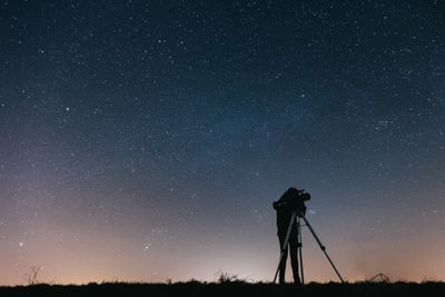 A silhouetted figure at a telescope under a starry sky — Thirdman on Pexels