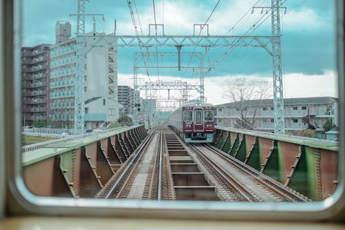 Gratis stockfoto met balustrades, bewegende trein, gebouwen