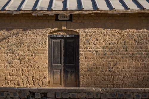 Free An old wooden door on a historic brick wall building with a 1903 date plaque. Stock Photo