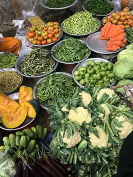 Assorted fresh vegetables displayed at a vibrant market stall in Dhaka, Bangladesh.