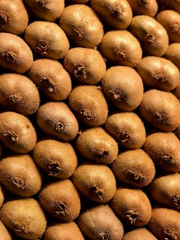 特写镜头中，新鲜成熟的奇异果堆叠在一起，展现出自然的纹理