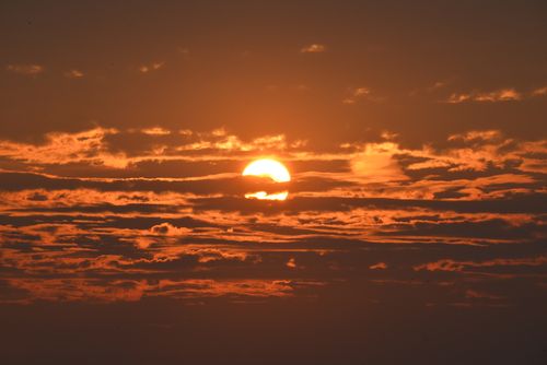 Free A breathtaking sunset with vibrant clouds creating a dramatic sky scene. Stock Photo